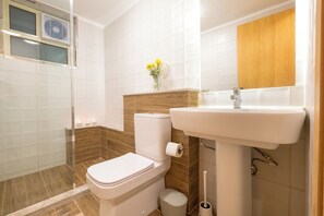 Ein Badezimmer mit Toilette, Waschbecken und Dusche.