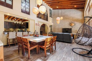 A spacious dining area with a high ceiling, wooden beams, and hanging spherical light fixtures. - Casa Avándaro with Pool, Garden & Jacuzzi (Valle de Bravo)