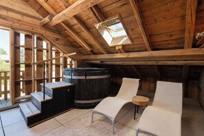 A wooden attic room with a skylight, a wooden barrel, a bench, and a chair. - Stone Lodge - 8 pers - Sauna - Bain nordique (Gérardmer)