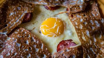 A breakfast dish with an egg, bacon, and toast.