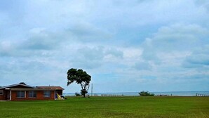 A house with a lawn and a tree in front. - Waterfront, Lighted Pier and Family Games! (Port Lavaca)