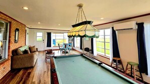 A pool area with a sofa, chairs, and a table. - Waterfront, Lighted Pier and Family Games! (Port Lavaca)