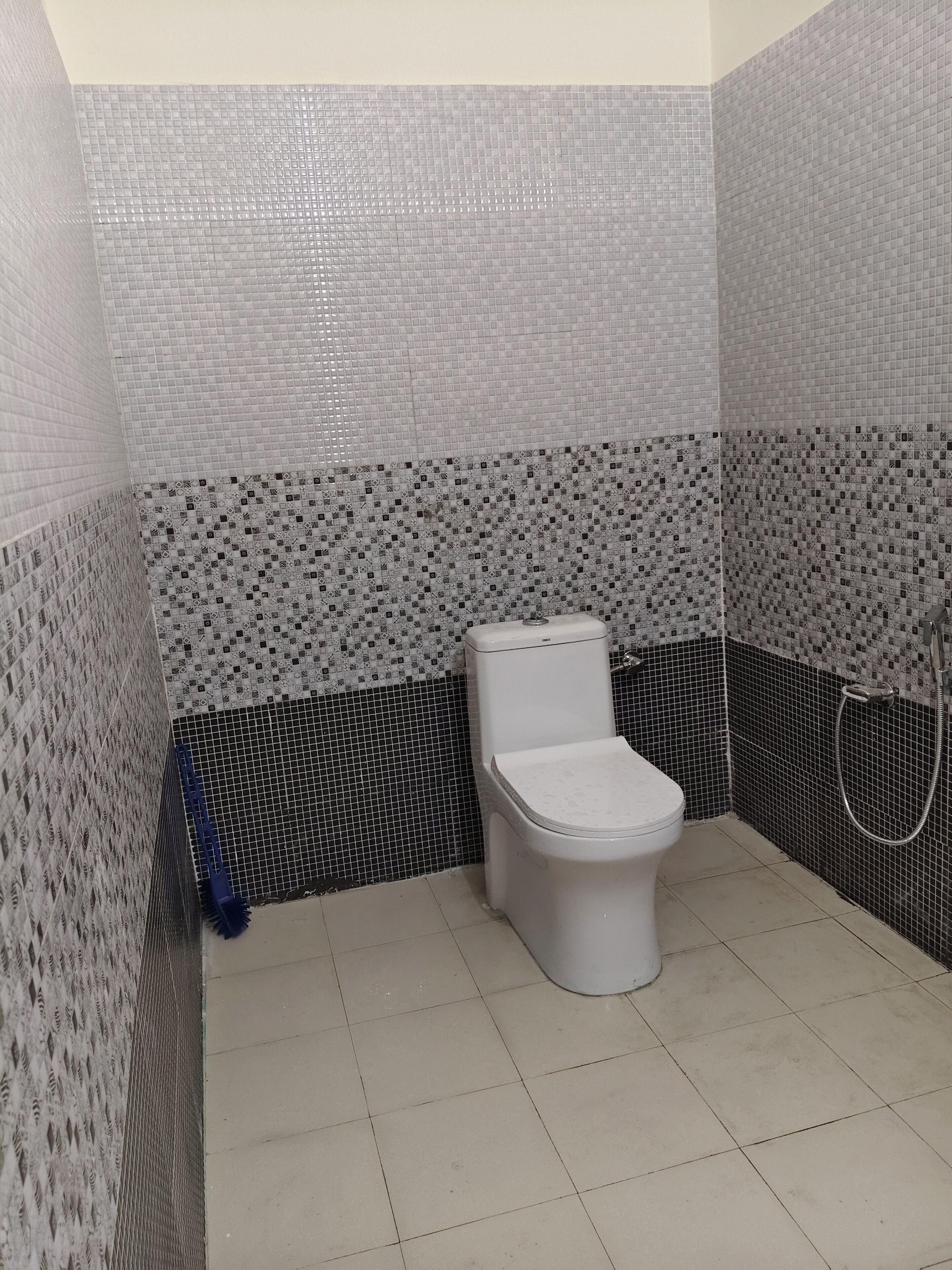 A bathroom with a toilet, a shower, and tiled walls.
