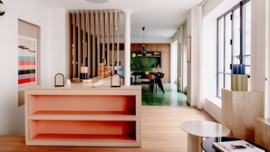 Ein modernes Interieur mit einem Holzbüro, einem Essbereich und einer im Hintergrund sichtbaren Küche.