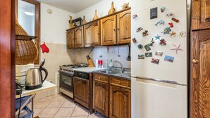 A kitchen with wooden cabinets, a stainless steel refrigerator, and various kitchen appliances.