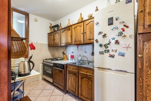 A kitchen with wooden cabinets, a stainless steel refrigerator, and various kitchen appliances.