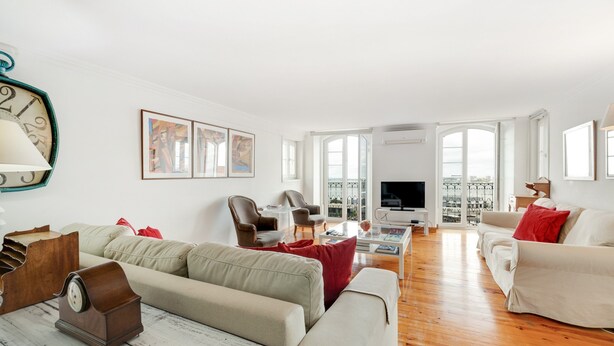 A spacious living room with a sofa, chairs, a coffee table, and a television. - Apartment 'Alfama Com Vista Rio' with Balcony, Wi-Fi and Air Conditioning (Lisboa)