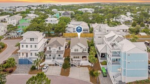 A residential area with houses, a green house, and a blue house. - Sea Charm | Close to Beach | Golf Cart (LSV) | Community Pool (Santa Rosa Beach)