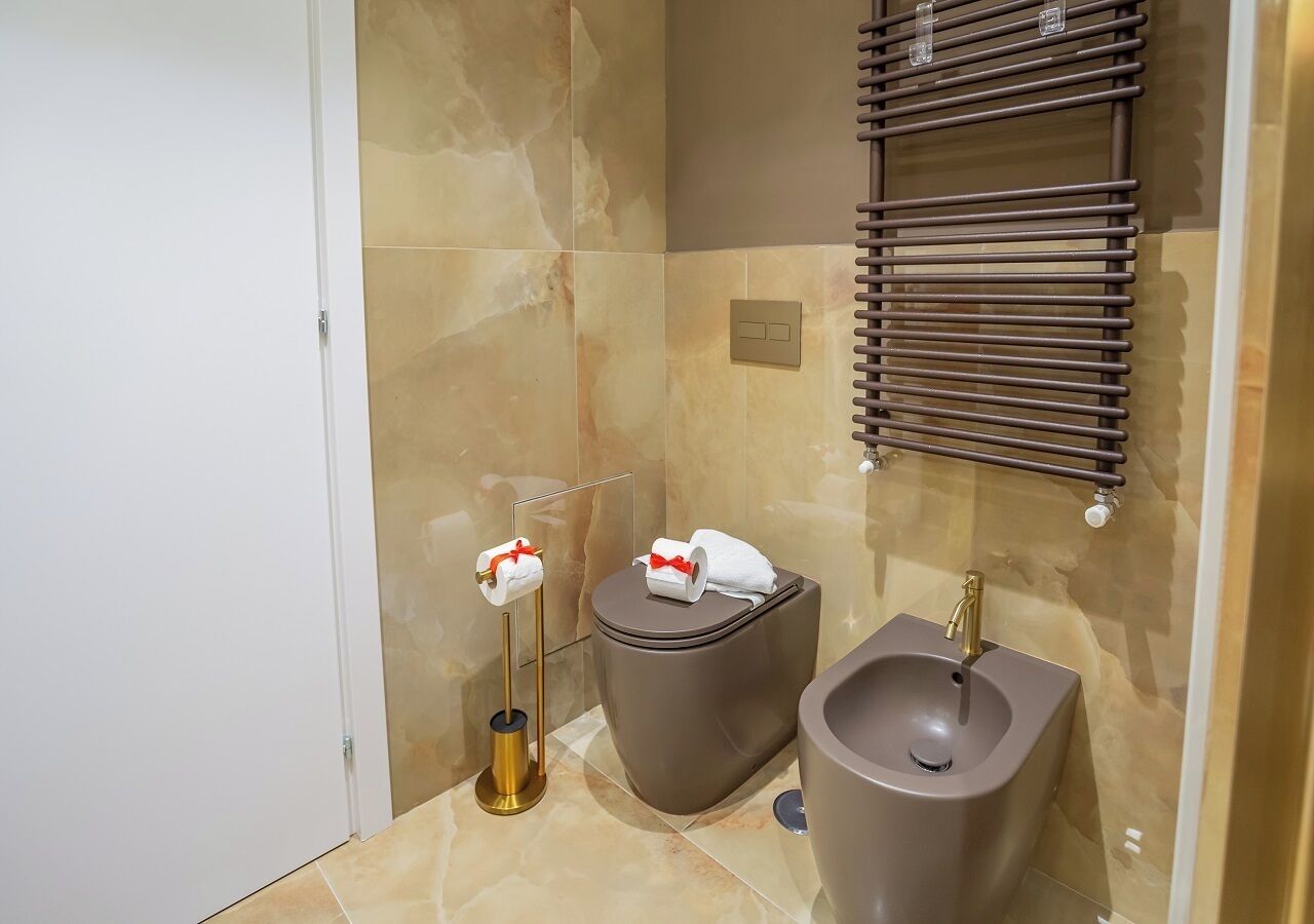 Ein modernes Badezimmer mit Toilette, Bidet und Waschbecken.