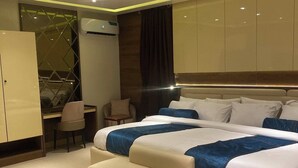 A modern bedroom with a large bed, a desk, and a wardrobe.