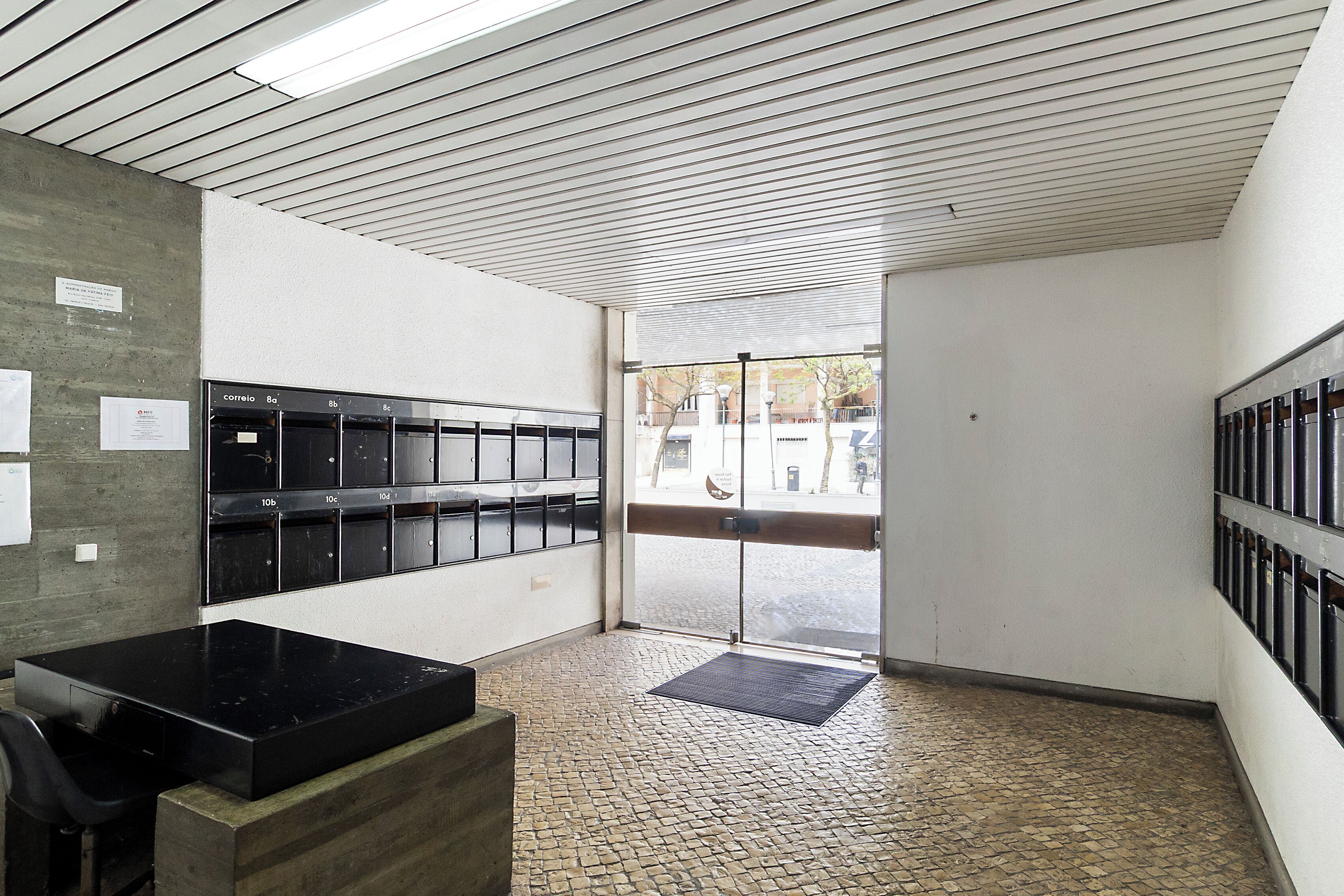 A locker room with a tiled floor, a bench, and a door leading outside.