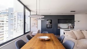Un intérieur moderne comprenant une table à manger, des chaises, un canapé et un coin cuisine.