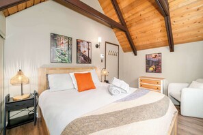 Ein Schlafzimmer mit einem Bett, einem Nachttisch, einer Kommode und Bildern an den Wänden.