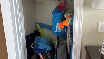 Un placard de rangement avec des étagères, une tringle et un sac suspendu.