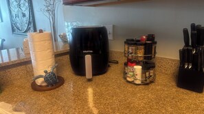 Eine Küchenarbeitsplatte mit Kaffeemaschine, Gewürzregal und Messerblock.