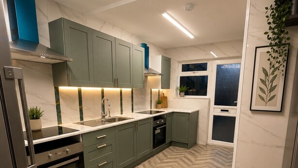 A modern kitchen with herringbone-patterned flooring, built-in appliances, and a herringbone-patterned backsplash.