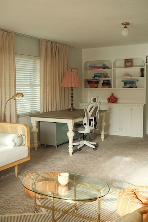 A room with a desk, chair, and a glass coffee table. - Casa Sol Boho chic pool home, sun soaked & spacious, king bed fireplace sleeps 8 (Fort Pierce)