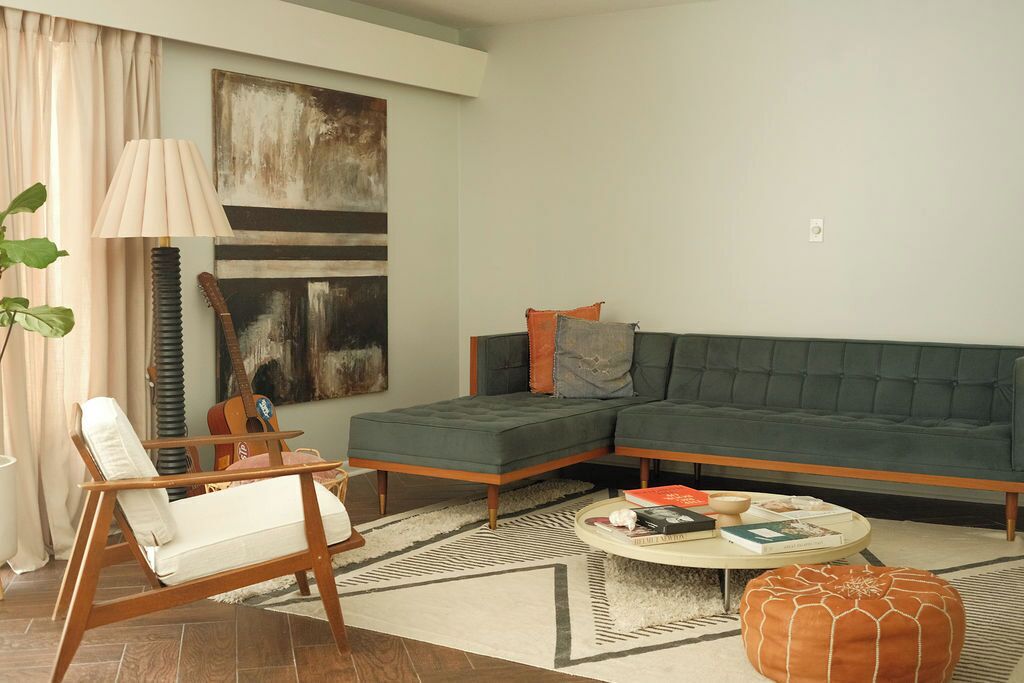 A modern living room with a sectional sofa, a wooden chair, a coffee table, and a lamp.