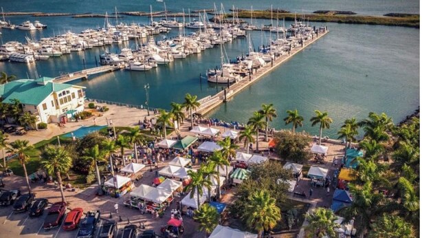 A marina with boats, a parking lot, and a building with a green roof. - Casa Sol Boho chic pool home, sun soaked & spacious, king bed fireplace sleeps 8 (Fort Pierce)