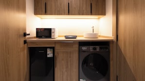 Una cocina compacta equipada con microondas, cafetera y lavavajillas.