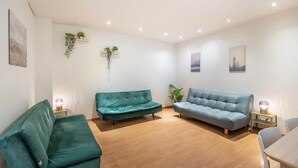 A modern living room with two sofas, a dining table, and a small side table with a lamp. - Lively City Getaway for 10 Near Meir (Antwerp)