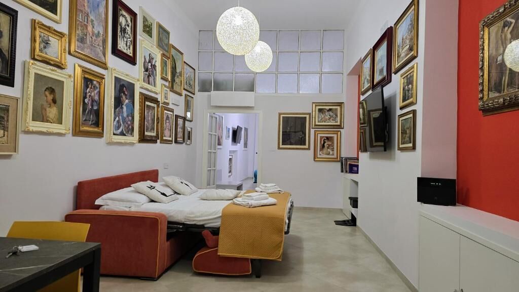 Un dormitorio con una cama, un escritorio y un televisor.