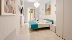 Un dormitorio moderno con cama, mesita de noche y obras de arte en las paredes.