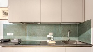 Una cocina moderna con horno empotrado, cafetera y lavabo.
