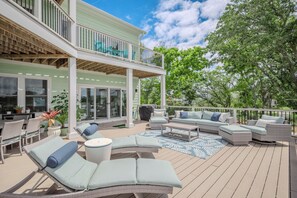 Une terrasse extérieure couverte, aménagée avec des meubles en osier, une piscine et un coin repas.