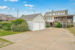 Ein Wohnhaus mit Garage, überdachter Veranda und Auffahrt.