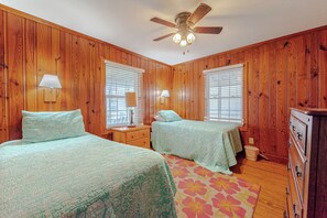 A bedroom with two beds, wooden walls, a ceiling fan, and a wooden dresser. - JL #426 | J. Jones - Oceanfront - Pet Friendly (Nags Head)