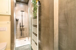Ein Badezimmer mit Dusche, Toilette und Handtuchhalter.