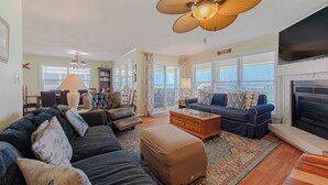 Ein Wohnzimmer mit Sofa, Hocker, Couchtisch und Kamin.