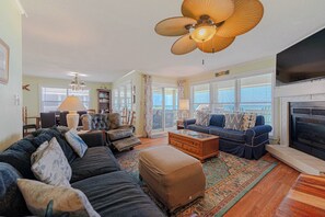 Ein Wohnzimmer mit Sofa, Hocker, Couchtisch und Kamin.