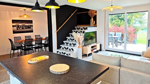 A modern interior with a dining area, a kitchen island, a staircase, and a TV. - La villa des cimes - Close to the lake (Tresserve)