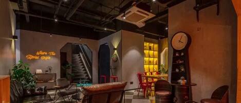 Ein modernes Interieur mit einem Schachbrettmuster-Boden, Ledersitzmöbeln, einer Treppe und einem Neonlicht.