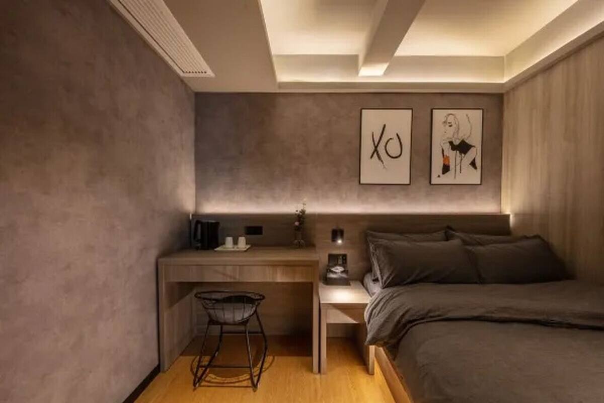 Un dormitorio pequeño con cama, escritorio y silla.