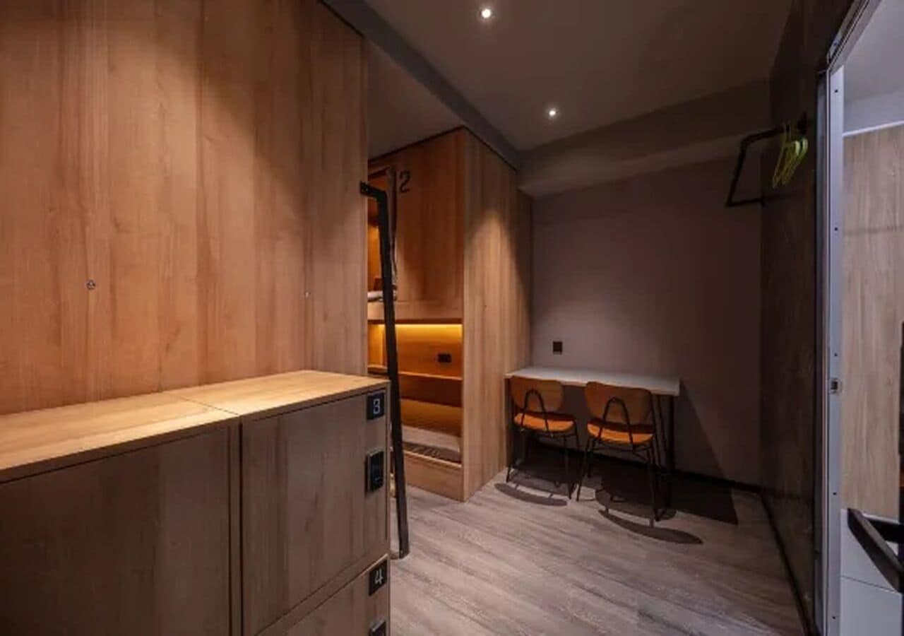 A room with wooden cabinets, a table with chairs, and a small seating area.