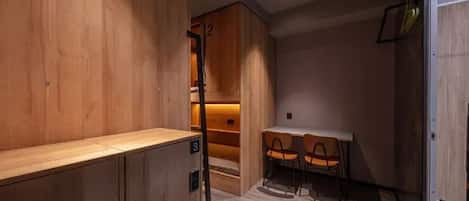 A room with wooden cabinets, a table with chairs, and a small seating area.