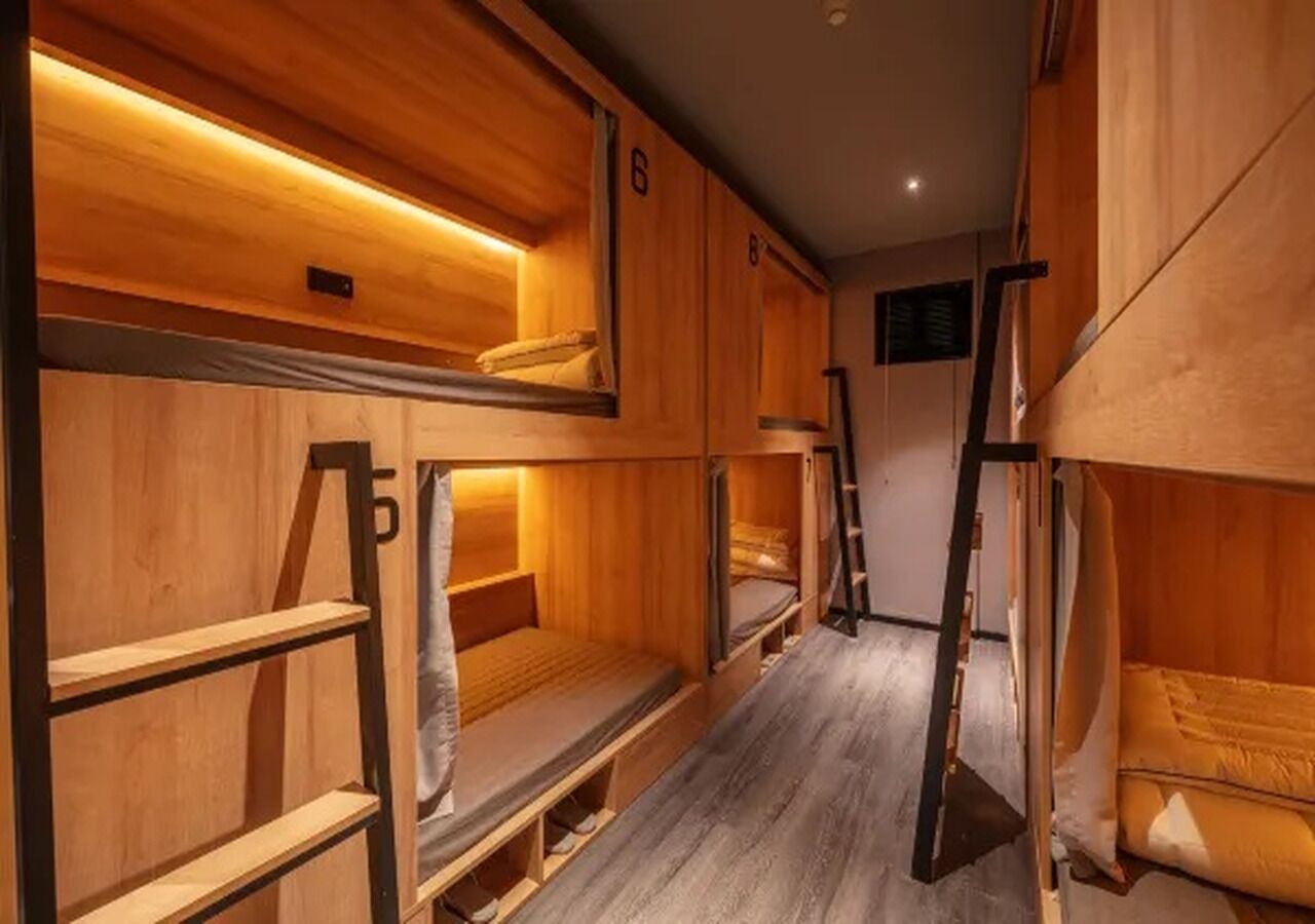 Une chambre avec un lit superposé, des murs en bois et une échelle.