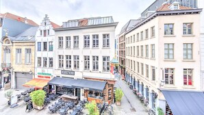 En gatubild med byggnader, uteservering och en skylt för ”PastaVino”.