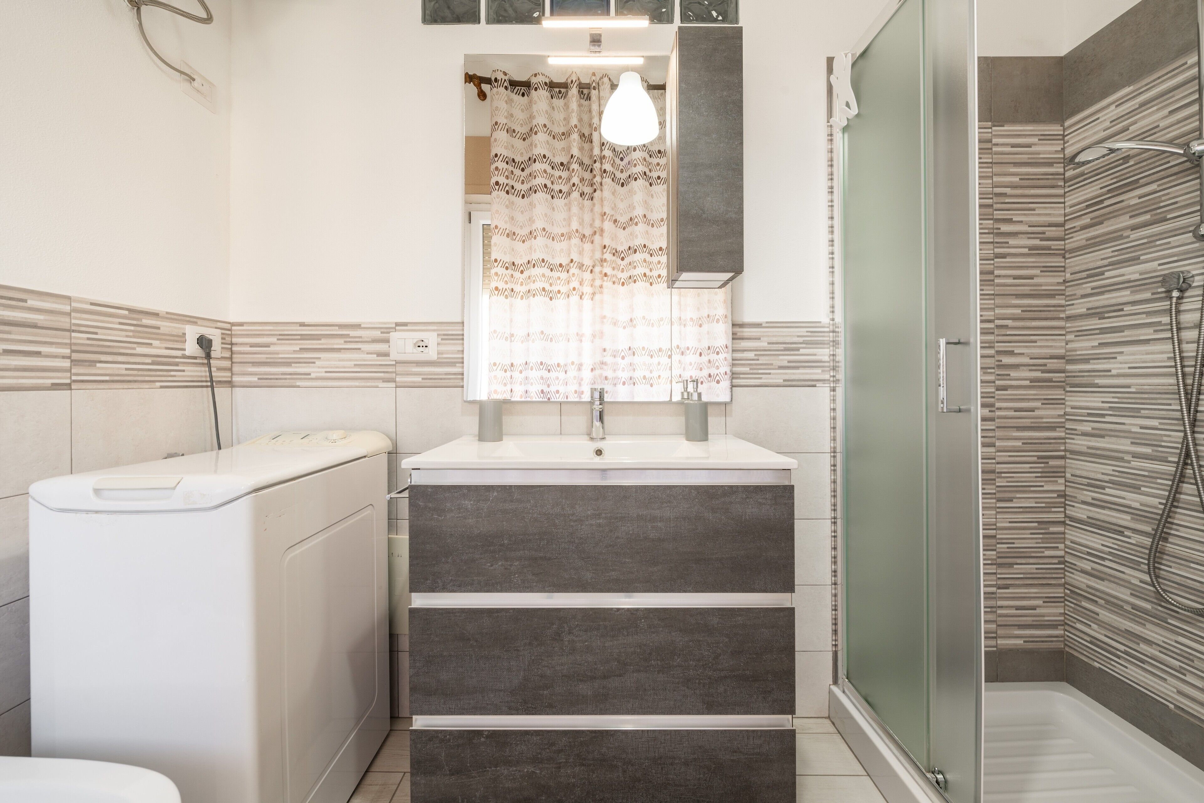 Une salle de bain au design moderne, comprenant une douche, des toilettes et un lavabo avec un miroir au-dessus.