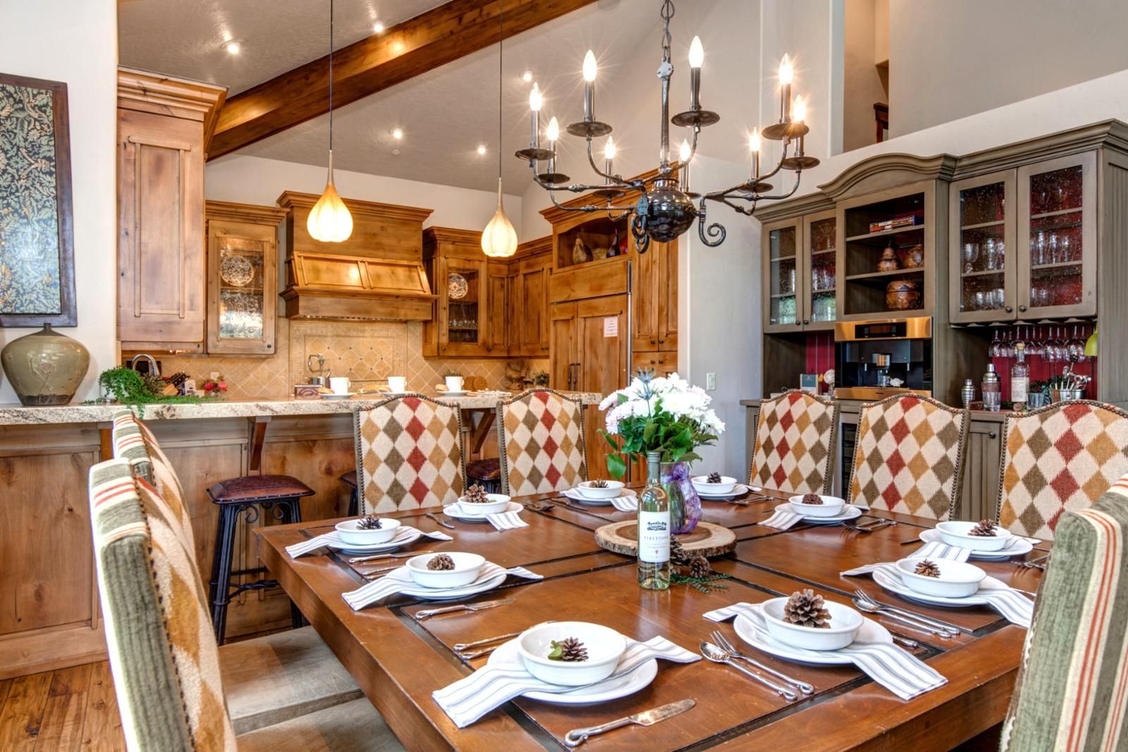 Un coin repas avec une table en bois, des chaises et un lustre.