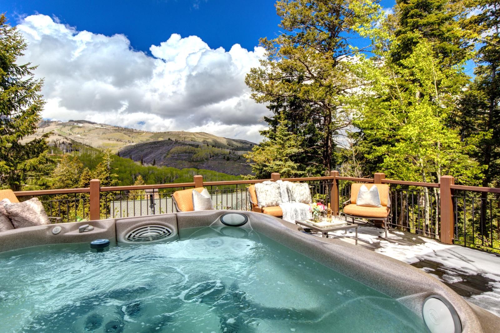 A hot tub with a view of mountains and trees.