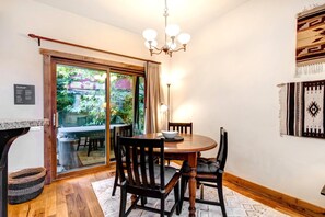 A dining area with a wooden table and chairs, a chandelier, and a view of greenery outside. - KBM Resorts | In the Heart of Old Town, Walk to Main St., Easy access shuttle to PCMR or DV Resorts, Private Hot Tub! POA-504b (Park City)