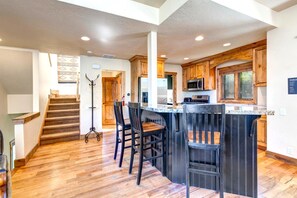 A spacious kitchen with wooden cabinets, a central island with bar stools, and a stainless steel refrigerator. - KBM Resorts | In the Heart of Old Town, Walk to Main St., Easy access shuttle to PCMR or DV Resorts, Private Hot Tub! POA-504b (Park City)