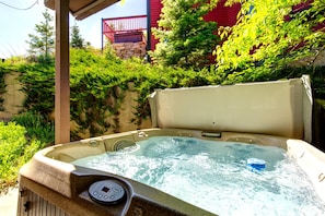 A hot tub with a control panel, surrounded by lush greenery and a stone wall. - KBM Resorts | In the Heart of Old Town, Walk to Main St., Easy access shuttle to PCMR or DV Resorts, Private Hot Tub! POA-504b (Park City)