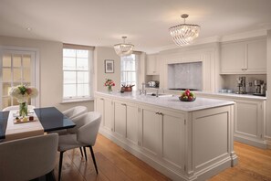 A spacious kitchen with a large island, white cabinetry, and modern appliances.