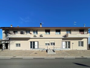 A two-story building with balconies, air conditioning units, and a gated entrance. - Mama Lidia (Creazzo)