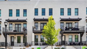 A row of modern townhouses with balconies, a central tree, and a clear sky. - 5-Min to the FIFA World Cup Games: Rooftop Patio + City Views (Atlanta)